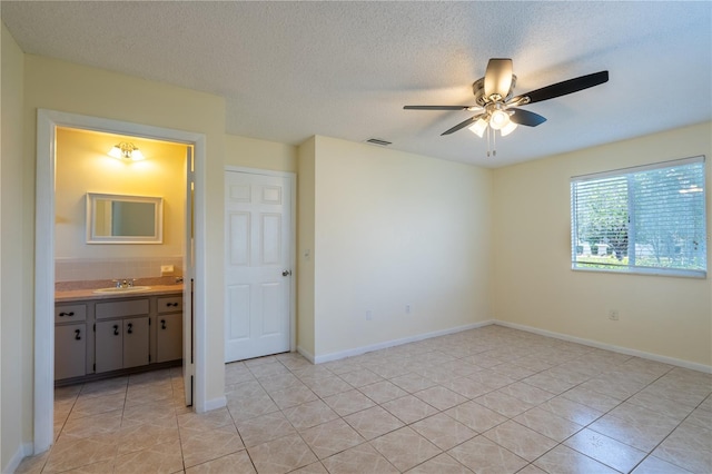 8463 SW 108th Pl, Ocala, FL 34481 - unfurnished bedroom featuring light tile patterned flooring, ensuite bath, a textured ceiling, and a ceiling fan