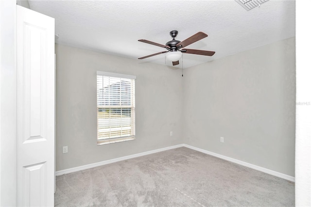 carpeted spare room featuring ceiling fan, baseboards, and a textured ceiling