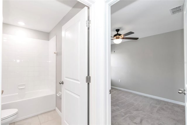 bathroom featuring ceiling fan, toilet, baseboards, and shower / bathtub combination