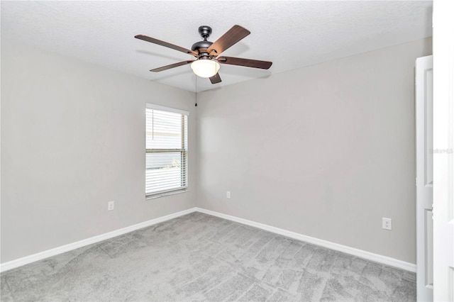 spare room with carpet floors, ceiling fan, baseboards, and a textured ceiling