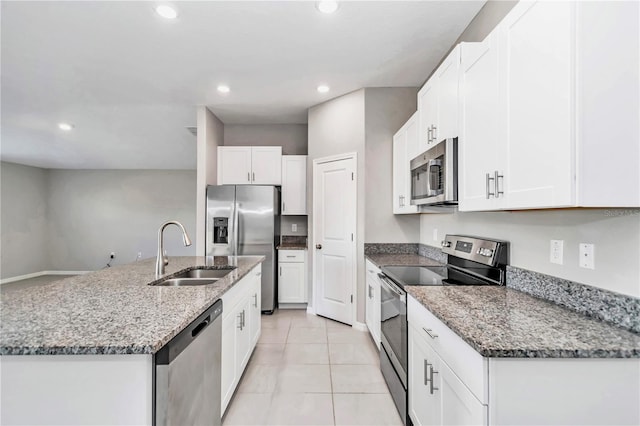 kitchen featuring stainless steel appliances, a sink, recessed lighting, white cabinetry, and stone countertops
