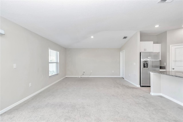 unfurnished living room featuring baseboards, light colored carpet, and recessed lighting