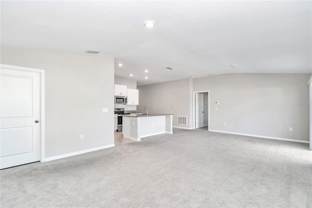 unfurnished living room with baseboards, light colored carpet, a sink, and recessed lighting