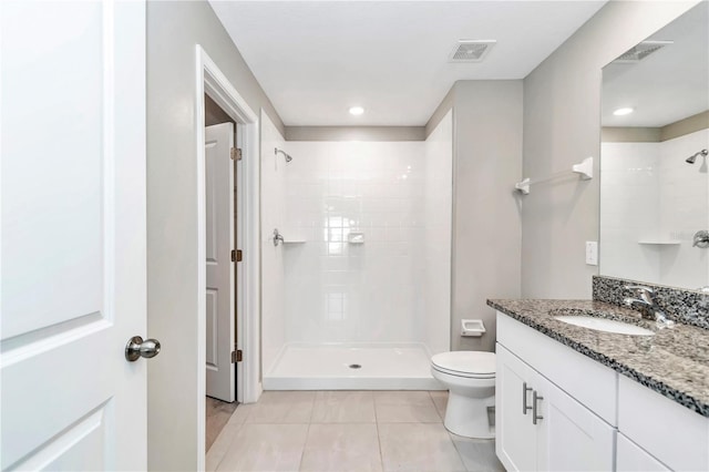 bathroom featuring a tile shower, tile patterned flooring, toilet, vanity, and recessed lighting