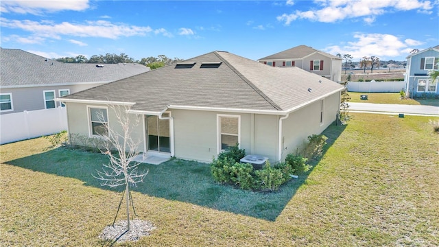 rear view of property with stucco siding and roof with shingles