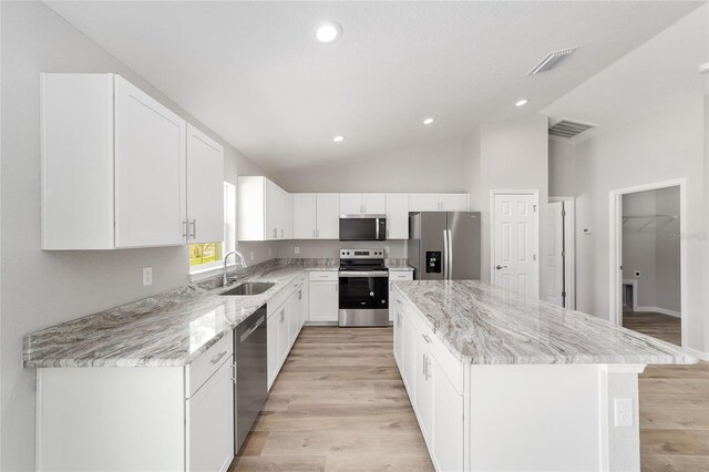 25 Juniper Pass Way, Ocala, FL 34480 - kitchen featuring appliances with stainless steel finishes, a sink, a center island, light stone countertops, and vaulted ceiling
