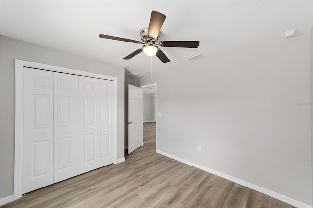 25 Juniper Pass Way, Ocala, FL 34480 - unfurnished bedroom featuring baseboards, a closet, light wood-style floors, and a ceiling fan