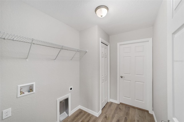 25 Juniper Pass Way, Ocala, FL 34480 - clothes washing area with wood finished floors, washer hookup, hookup for an electric dryer, baseboards, and a textured ceiling