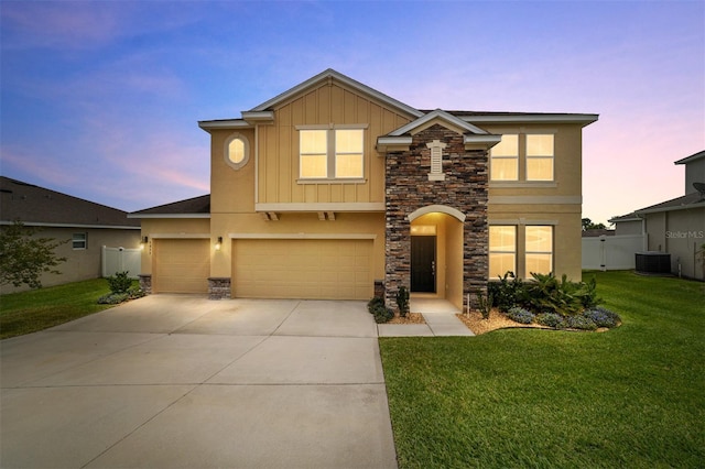 5653 SW 50th Ter, Ocala, FL 34474 - view of front facade with stone siding, board and batten siding, central AC unit, driveway, and a garage