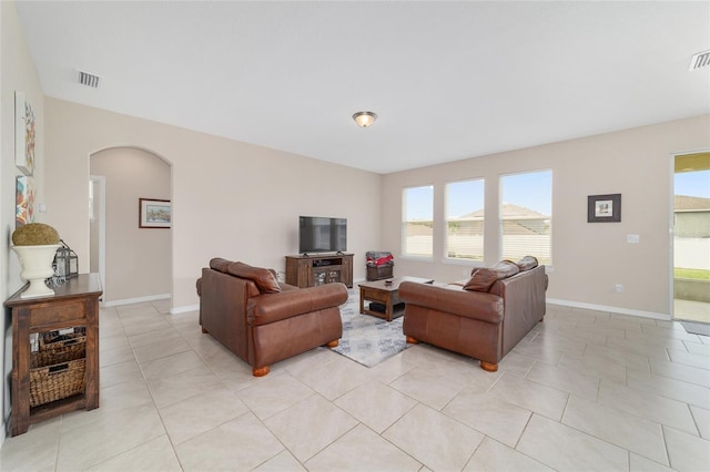 5653 SW 50th Ter, Ocala, FL 34474 - living area with arched walkways, healthy amount of natural light, baseboards, and light tile patterned floors