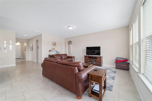 5653 SW 50th Ter, Ocala, FL 34474 - living room with arched walkways, light tile patterned flooring, and baseboards