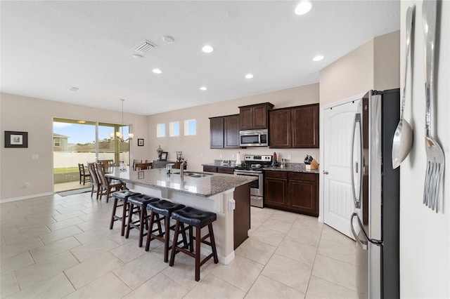 5653 SW 50th Ter, Ocala, FL 34474 - kitchen with appliances with stainless steel finishes, a kitchen bar, a sink, stone counters, and a center island with sink