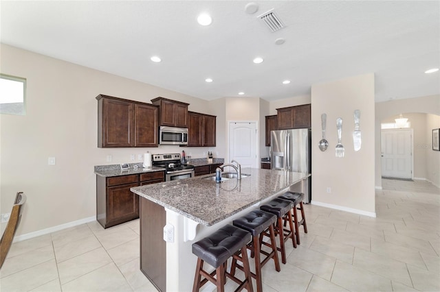 5653 SW 50th Ter, Ocala, FL 34474 - kitchen featuring appliances with stainless steel finishes, a sink, baseboards, a kitchen breakfast bar, and recessed lighting