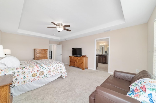 5653 SW 50th Ter, Ocala, FL 34474 - bedroom with a raised ceiling, light carpet, baseboards, a ceiling fan, and ensuite bathroom