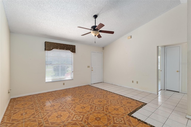 spare room featuring tile patterned floors, ceiling fan, a textured ceiling, and vaulted ceiling