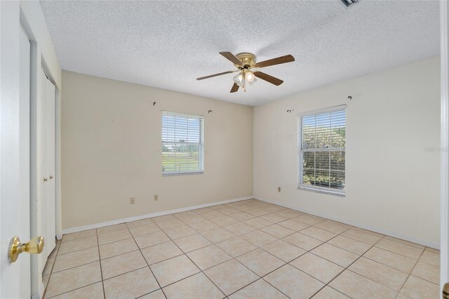 spare room with healthy amount of natural light, a ceiling fan, and a textured ceiling