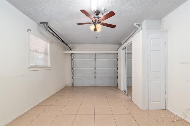 garage with a ceiling fan and baseboards