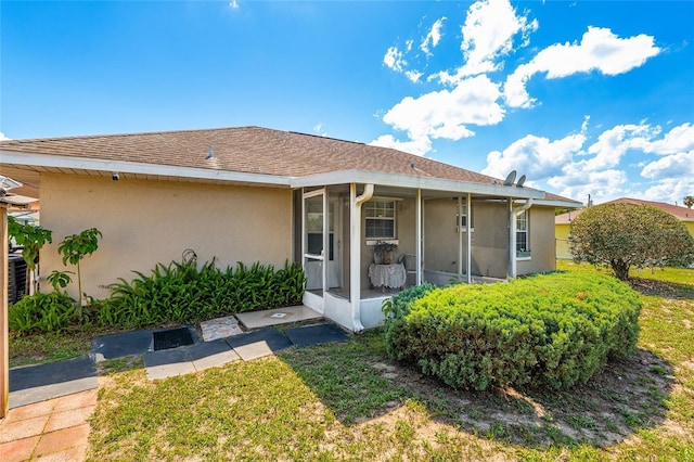 back of property featuring a sunroom, stucco siding, and central air condition unit