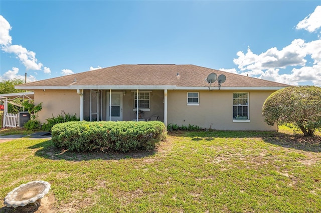 back of house with stucco siding, a yard, and a sunroom
