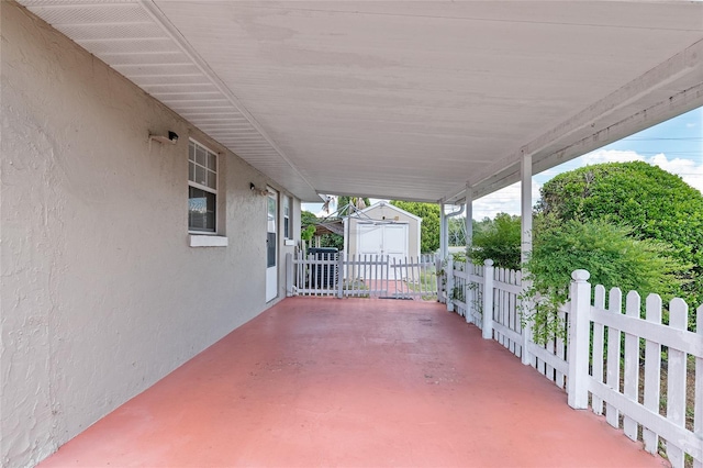 view of patio / terrace featuring a storage unit, an outdoor structure, and fence