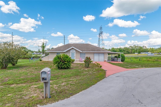ranch-style house with a front yard, stucco siding, and driveway