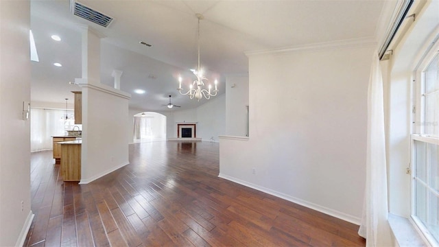 10528 SW 27th Ave, Ocala, FL 34476 - unfurnished living room featuring dark wood finished floors, a chandelier, baseboards, arched walkways, and crown molding