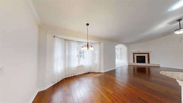 10528 SW 27th Ave, Ocala, FL 34476 - unfurnished living room with ornamental molding, ceiling fan, a chandelier, wood-type flooring, and a fireplace with raised hearth