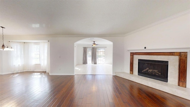 10528 SW 27th Ave, Ocala, FL 34476 - unfurnished living room with arched walkways, wood-type flooring, a fireplace, ornamental molding, and baseboards