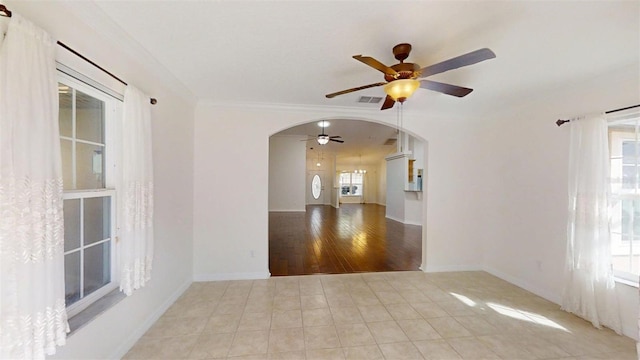 10528 SW 27th Ave, Ocala, FL 34476 - empty room featuring ceiling fan, arched walkways, light tile patterned floors, crown molding, and baseboards