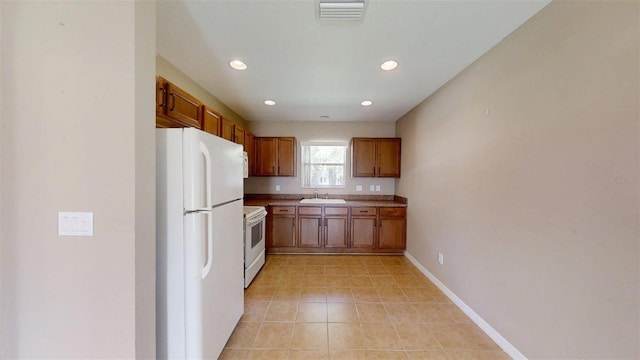 10528 SW 27th Ave, Ocala, FL 34476 - kitchen with white appliances, a sink, recessed lighting, brown cabinets, and baseboards