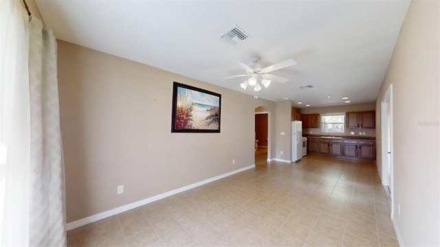 10528 SW 27th Ave, Ocala, FL 34476 - unfurnished living room featuring ceiling fan, arched walkways, baseboards, a sink, and light tile patterned floors