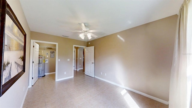 10528 SW 27th Ave, Ocala, FL 34476 - unfurnished bedroom featuring water heater, light tile patterned flooring, baseboards, and ceiling fan