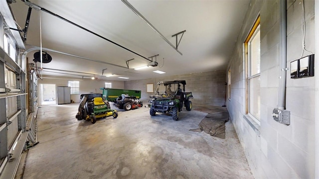 10528 SW 27th Ave, Ocala, FL 34476 - garage with a garage door opener, concrete block wall, and freestanding refrigerator