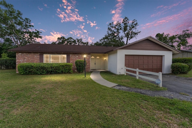 2146 NE 9th St, Ocala, FL 34470 - ranch-style home with a garage, a front lawn, asphalt driveway, and brick siding