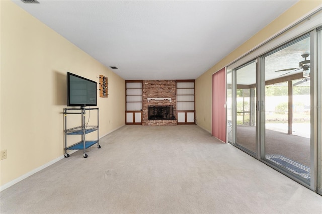 2146 NE 9th St, Ocala, FL 34470 - unfurnished living room featuring carpet flooring, ceiling fan, baseboards, a fireplace, and built in shelves
