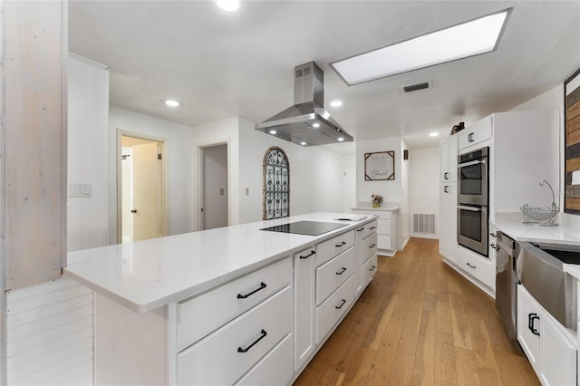 2146 NE 9th St, Ocala, FL 34470 - kitchen with island range hood, appliances with stainless steel finishes, white cabinets, recessed lighting, and a kitchen island