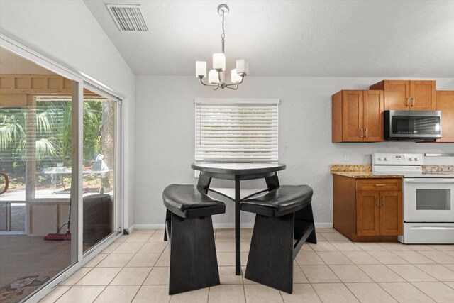 3728 S Eastpark Way, Homosassa, FL 34446 - kitchen with stainless steel microwave, electric stove, a chandelier, brown cabinets, and light tile patterned flooring