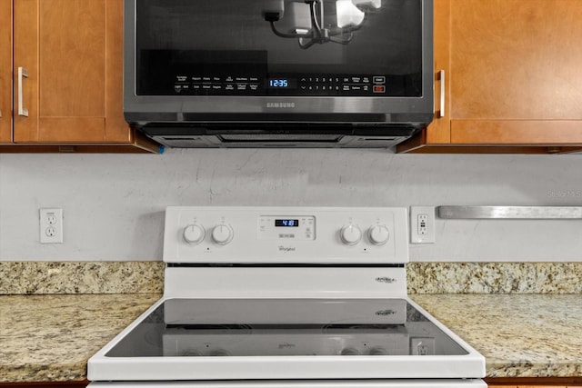 3728 S Eastpark Way, Homosassa, FL 34446 - kitchen view of white electric range oven, stainless steel microwave, and brown cabinetry