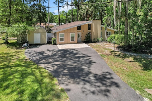 3728 S Eastpark Way, Homosassa, FL 34446 - mid-century home featuring driveway, a storage unit, an outbuilding, and a front lawn