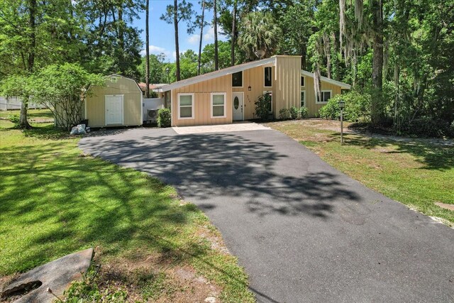 3728 S Eastpark Way, Homosassa, FL 34446 - mid-century home featuring a storage shed, driveway, an outbuilding, and a front yard