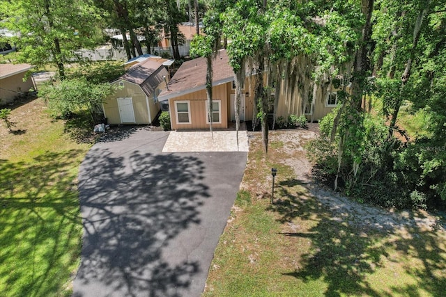 3728 S Eastpark Way, Homosassa, FL 34446 - view of front of property with a shed, an outbuilding, asphalt driveway, and a front lawn