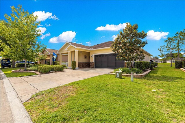 9642 SW 95th Loop, Ocala, FL 34481 - view of front of home with stucco siding, a garage, driveway, and a front lawn