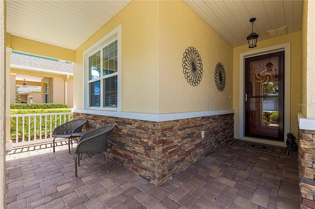 9642 SW 95th Loop, Ocala, FL 34481 - entrance to property with a porch, stucco siding, and stone siding