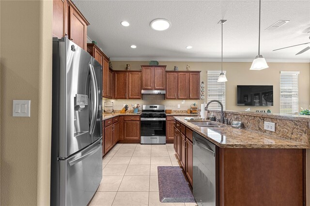 9642 SW 95th Loop, Ocala, FL 34481 - kitchen with stainless steel appliances, under cabinet range hood, brown cabinetry, light stone counters, and light tile patterned floors