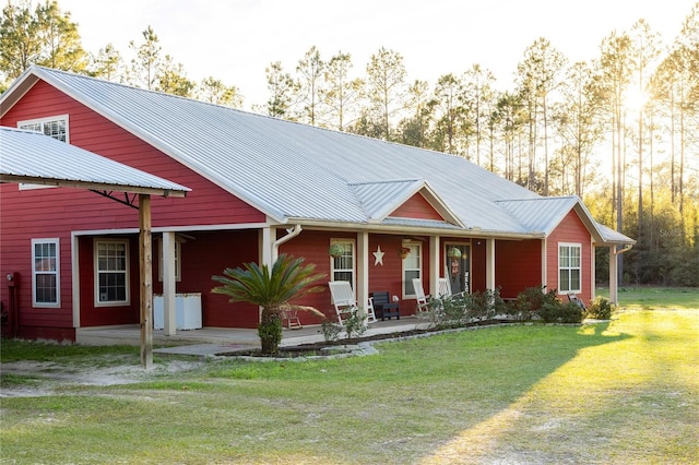 831 SE 11th Pl, Williston, FL 32696 - view of front of house with covered porch, a front yard, and a metal roof