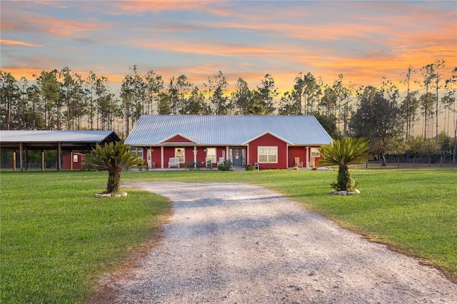 831 SE 11th Pl, Williston, FL 32696 - ranch-style house featuring gravel driveway, a yard, a carport, and a metal roof