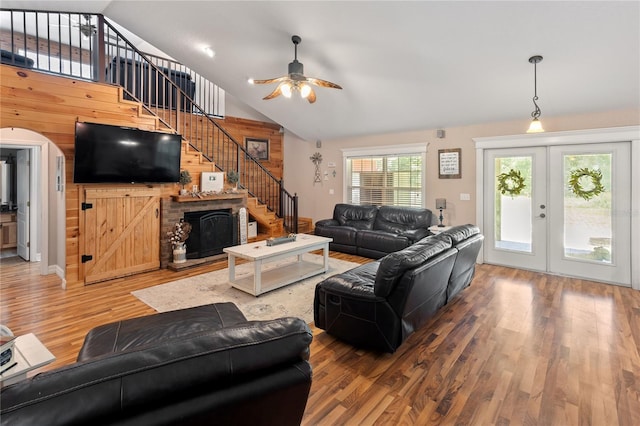 831 SE 11th Pl, Williston, FL 32696 - living room featuring ceiling fan, wood finished floors, stairs, wooden walls, and a fireplace