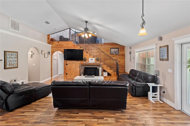 831 SE 11th Pl, Williston, FL 32696 - living area with wooden walls, lofted ceiling, wood finished floors, ceiling fan, and stairway