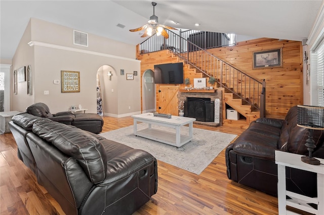 831 SE 11th Pl, Williston, FL 32696 - living area with wood walls, a ceiling fan, arched walkways, high vaulted ceiling, and stairway