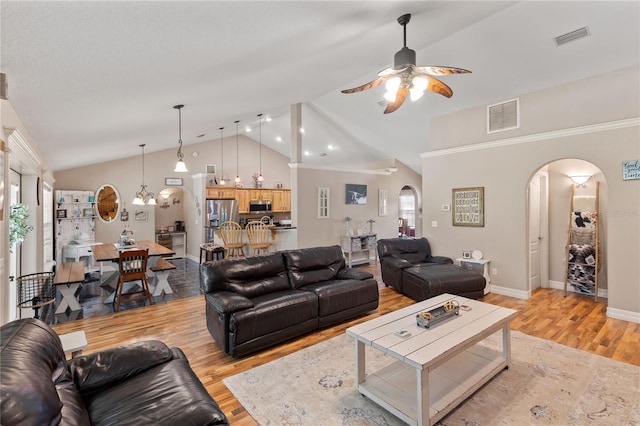 831 SE 11th Pl, Williston, FL 32696 - living room with arched walkways, ceiling fan, light wood finished floors, vaulted ceiling, and a chandelier